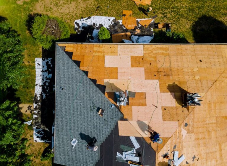 Overhead picture of men on roof adding asphalt shingles to the roof.