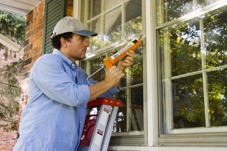 Man caulking a window.