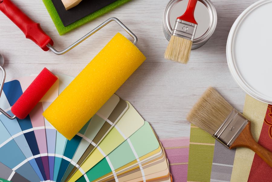 Image of paint brushes, rollers, paint cans and color swatches.